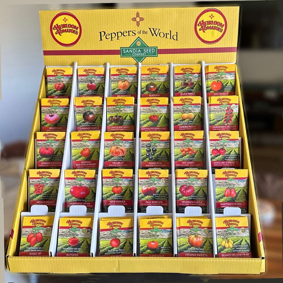 Wholesale Tomato Seed Assortment - 30 Varieties | 180 Packets neatly arranged in a yellow retail display box labeled 'Peppers of the World'.