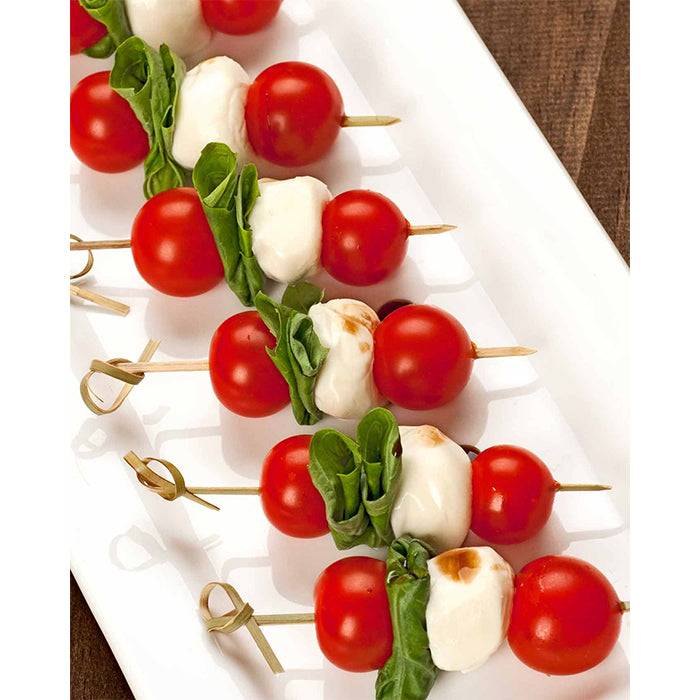 Caprese skewers with Large Red Cherry Tomatoes, mozzarella, and basil, highlighting the tomato's sweet flavor and culinary versatility.