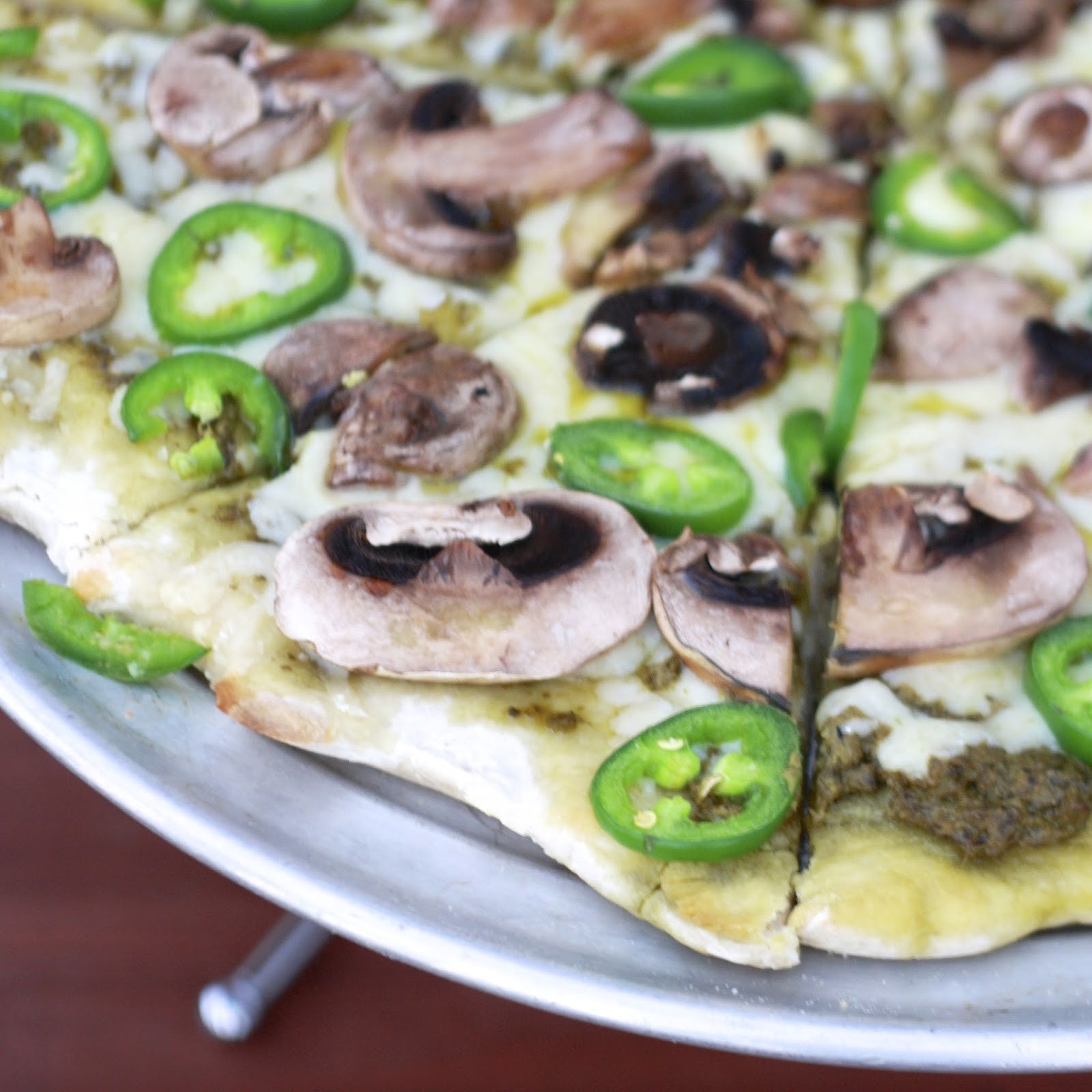 Pizza topped with sliced Jalapeño Early peppers and mushrooms, highlighting the fresh, spicy flavor of homegrown jalapeños.