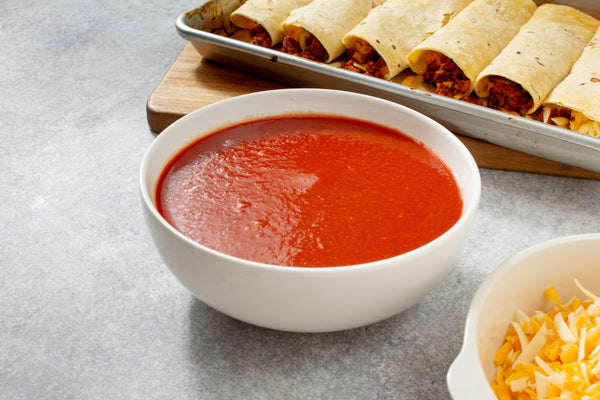 Enchilada Sauce Recipe - bowl of sauce shown with enchiladas and cheese
