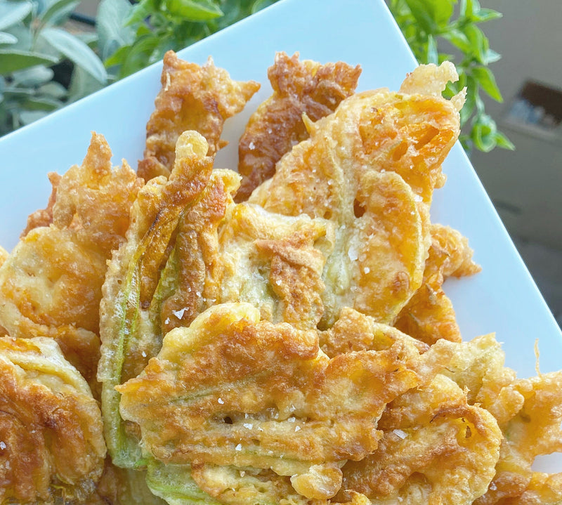 Golden fried zucchini blossoms with crispy batter, perfect for a delicious appetizer or gourmet snack in Italian cuisine.